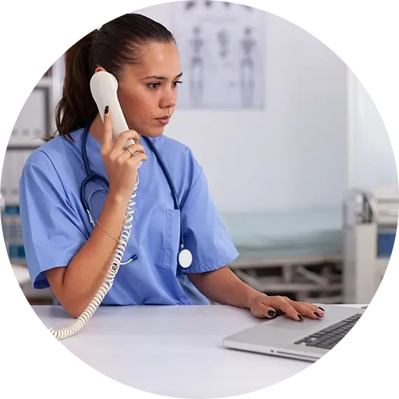 Young adult woman wearing scrubs and stethoscope on the phone